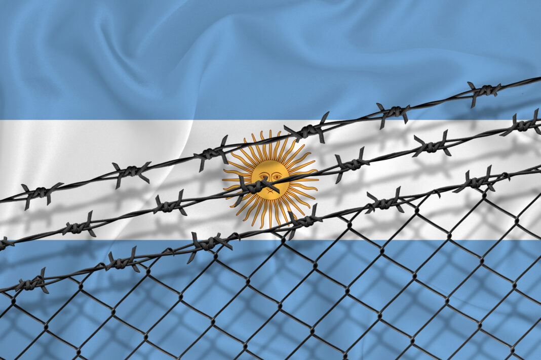 Bandera Argentina detrás de alambrado de puas.